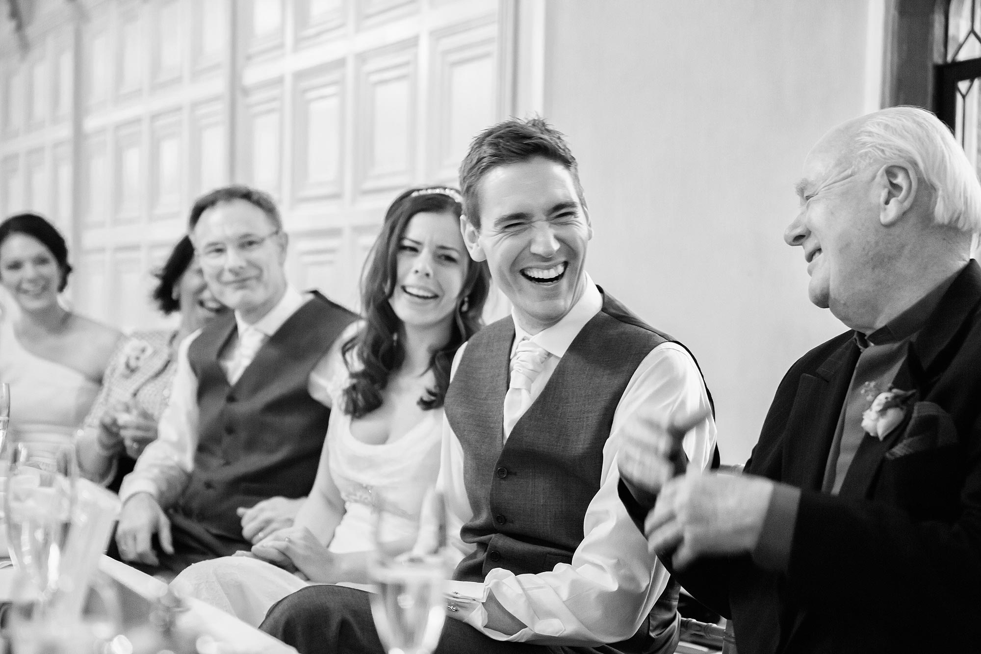 The groom laughs at his best man's speech