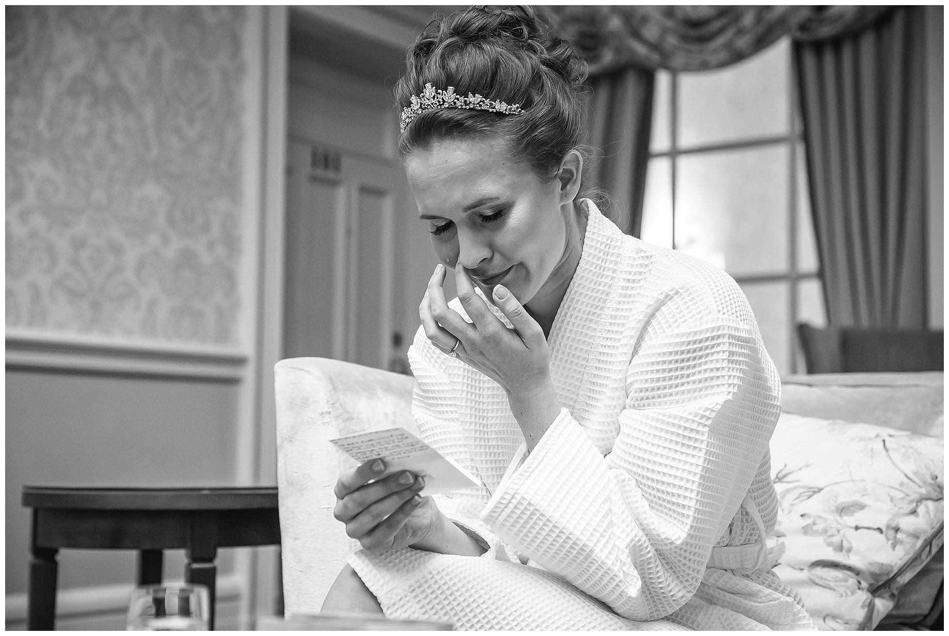 Bride reads card on morning of wedding