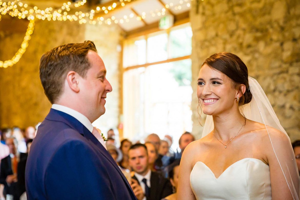 bride and groom smile at each other