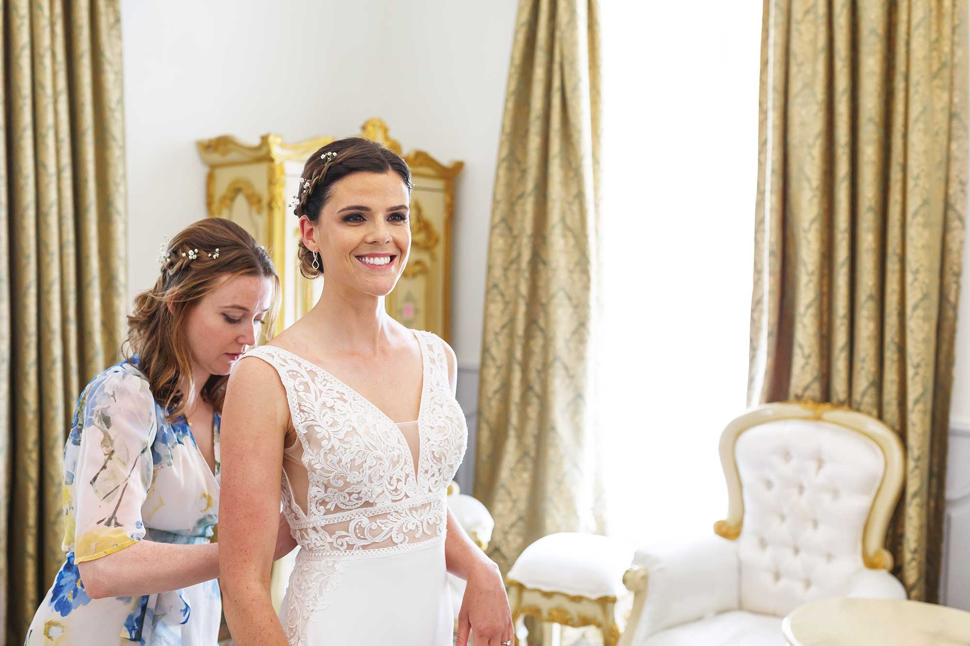 bridesmaid does up bridal gown at Chateau Rieutort wedding