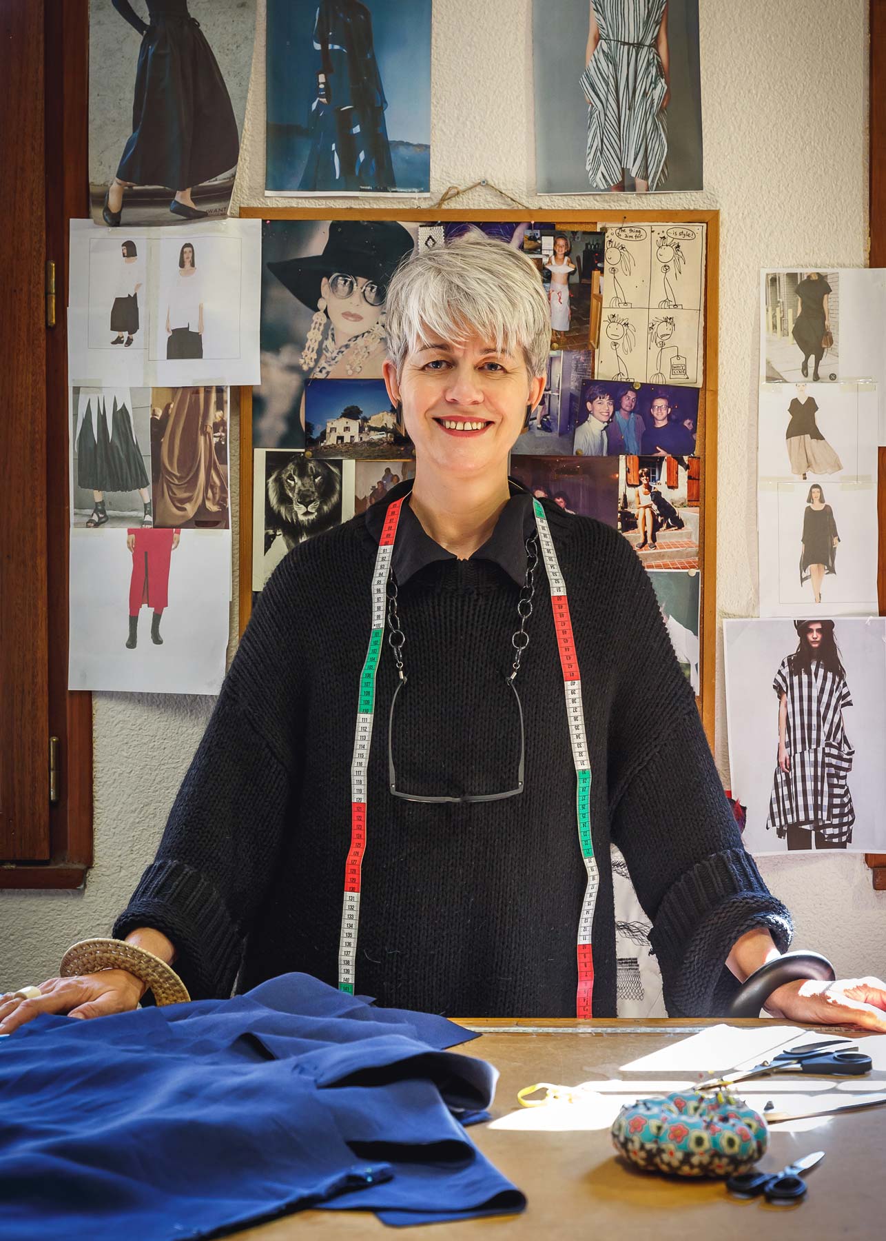 Woman with a measuring tape standing at a worktable