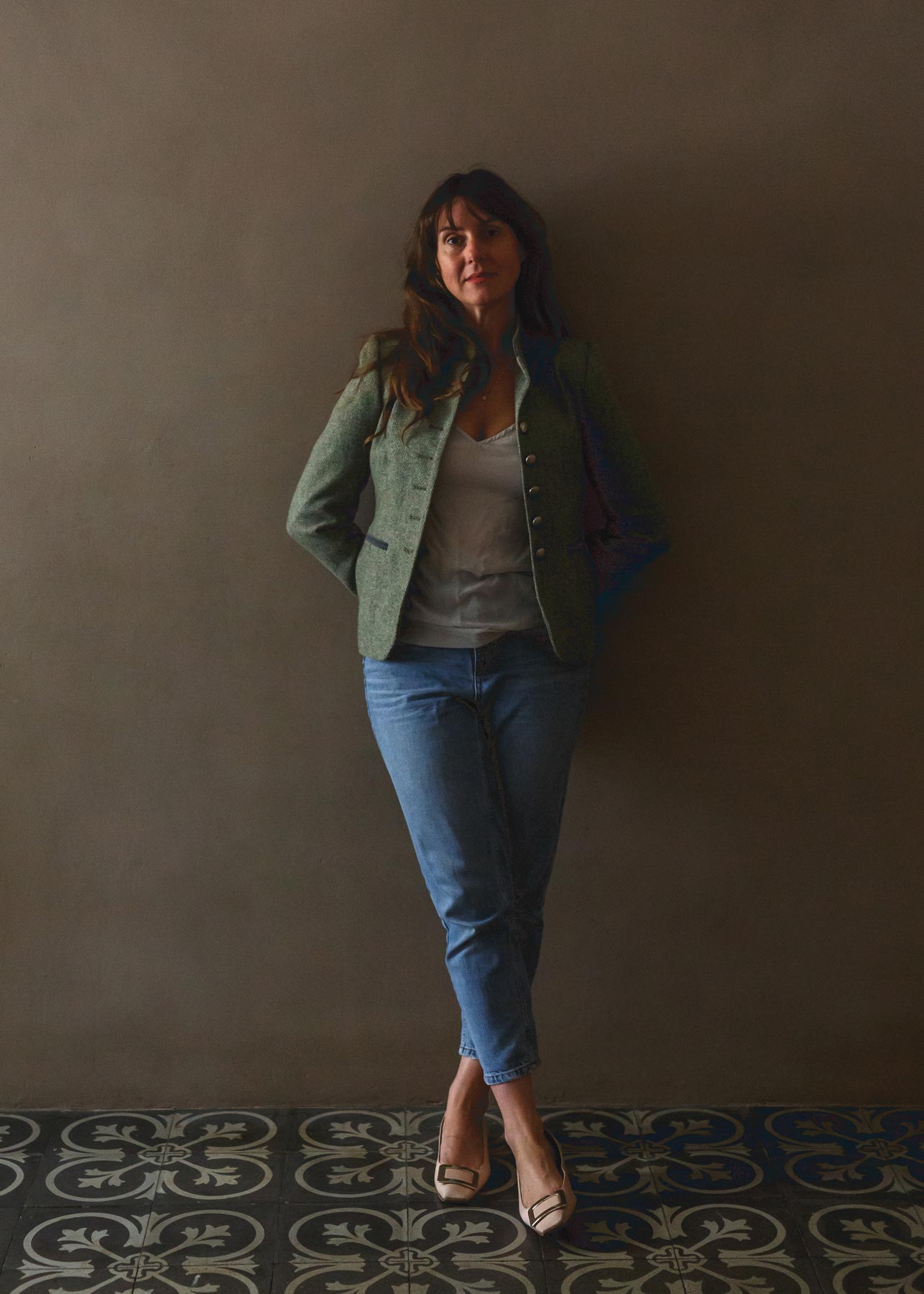 Woman standing in a dark, softly lit interior