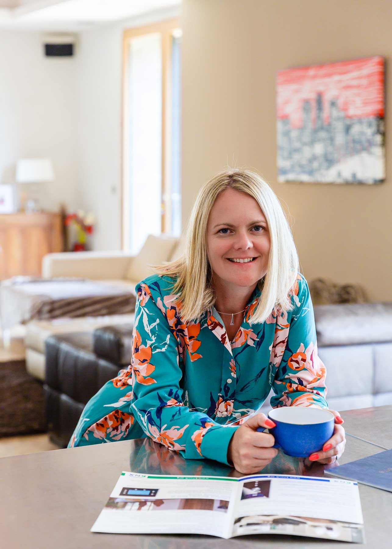 Woman sitting at a table with a mug and printed material