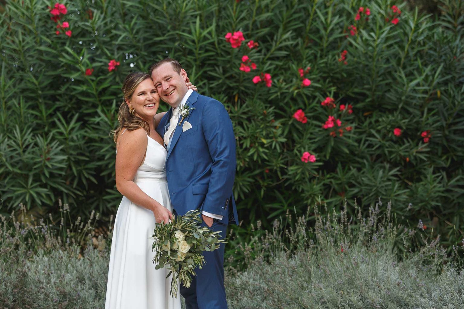 Bride and groom portrait beside pink oleander at Domaine Saint Hilaire