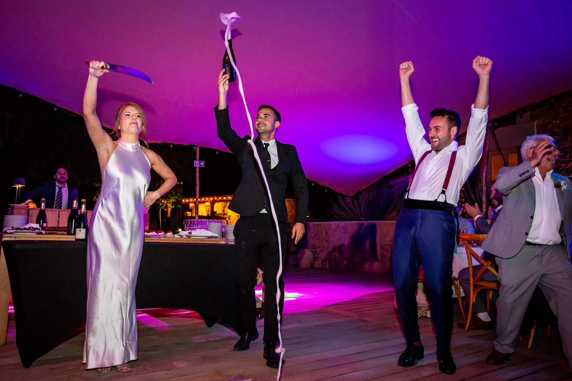 Bride opens champagne using sword at Wedding at Domaine de Noé