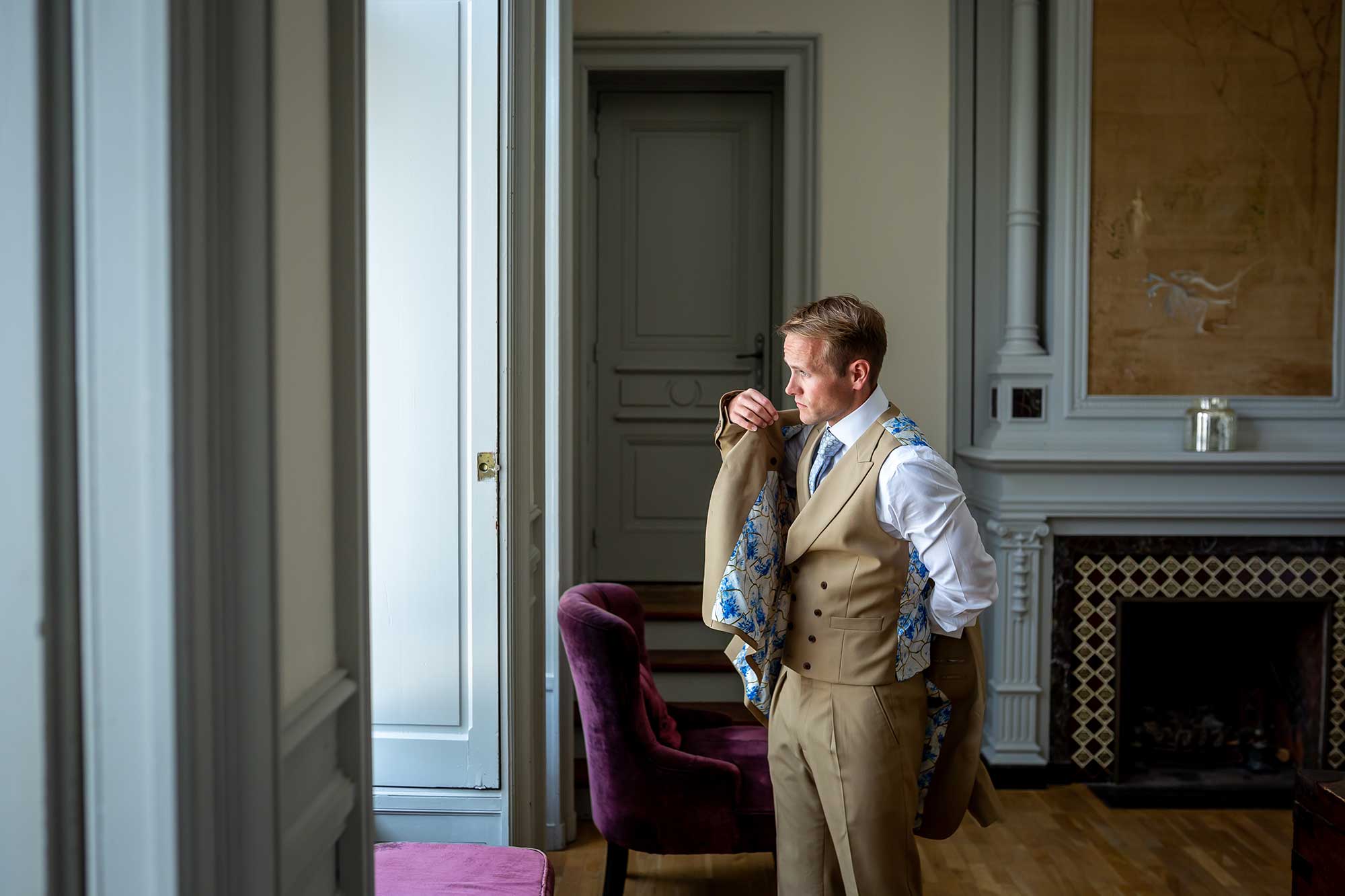 Groom puts on his jacket at his Chateau Carrasses vineyard wedding 