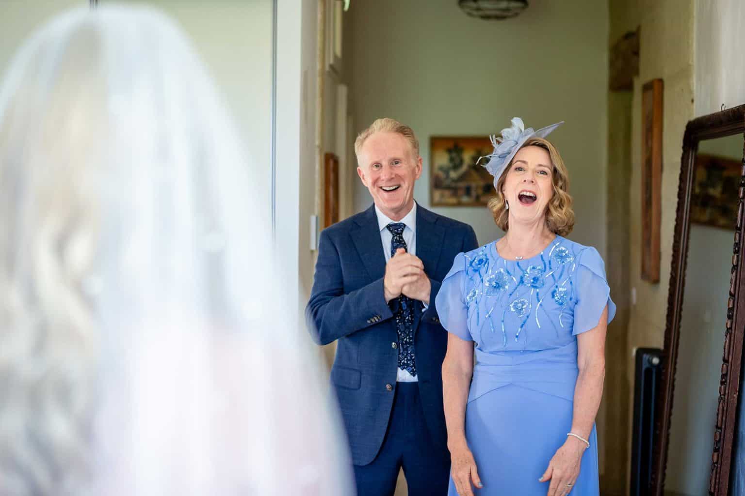 Bride laughing with two guests during wedding preparations at Château de Pondres