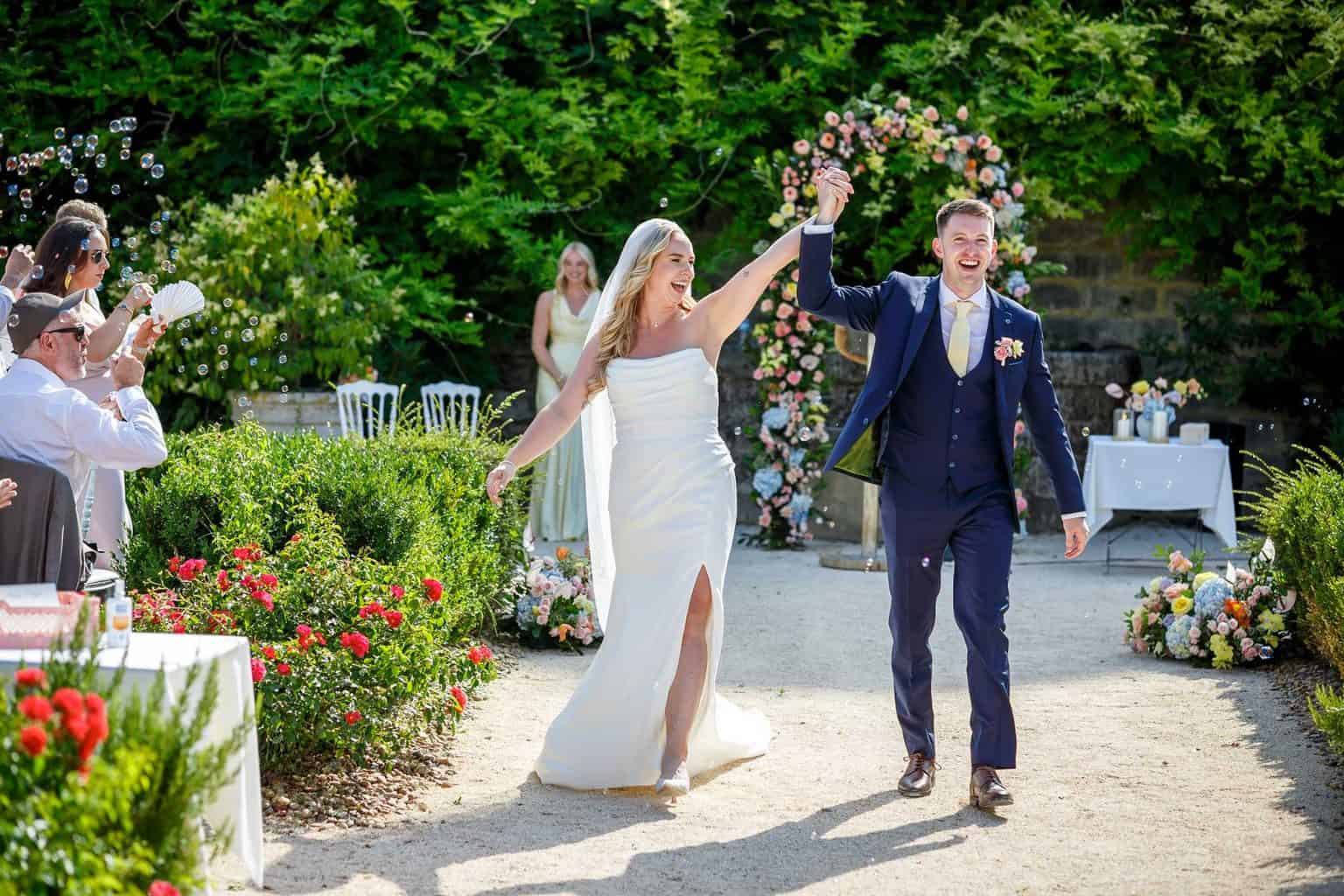 Newlyweds leaving their outdoor ceremony at Château de Pondres