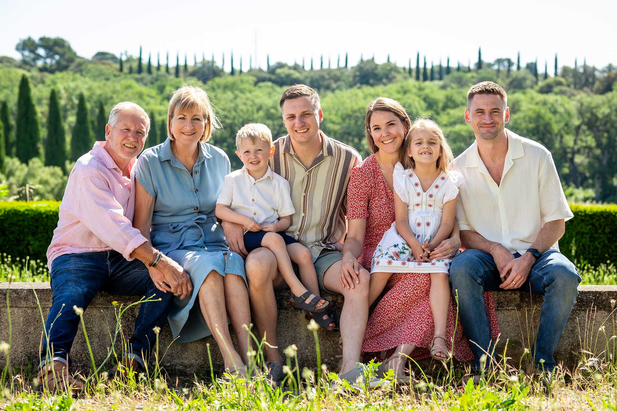 Seven family members sitting together in the countryside