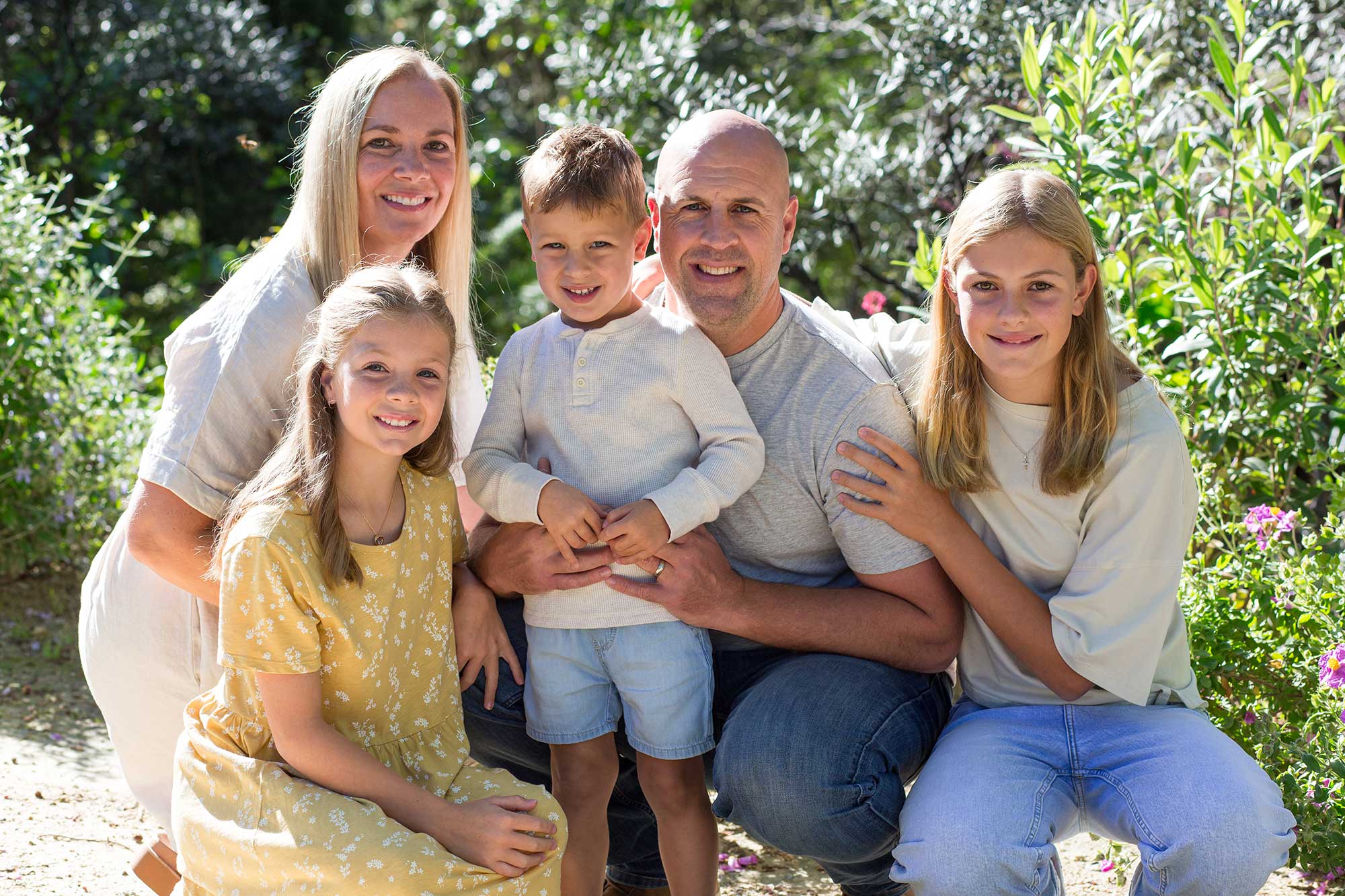 Five family members sitting together outdoors