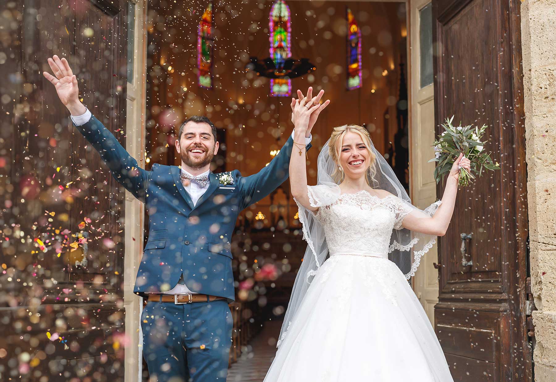 Newlyweds celebrating outside the church at their wedding near Montpellier