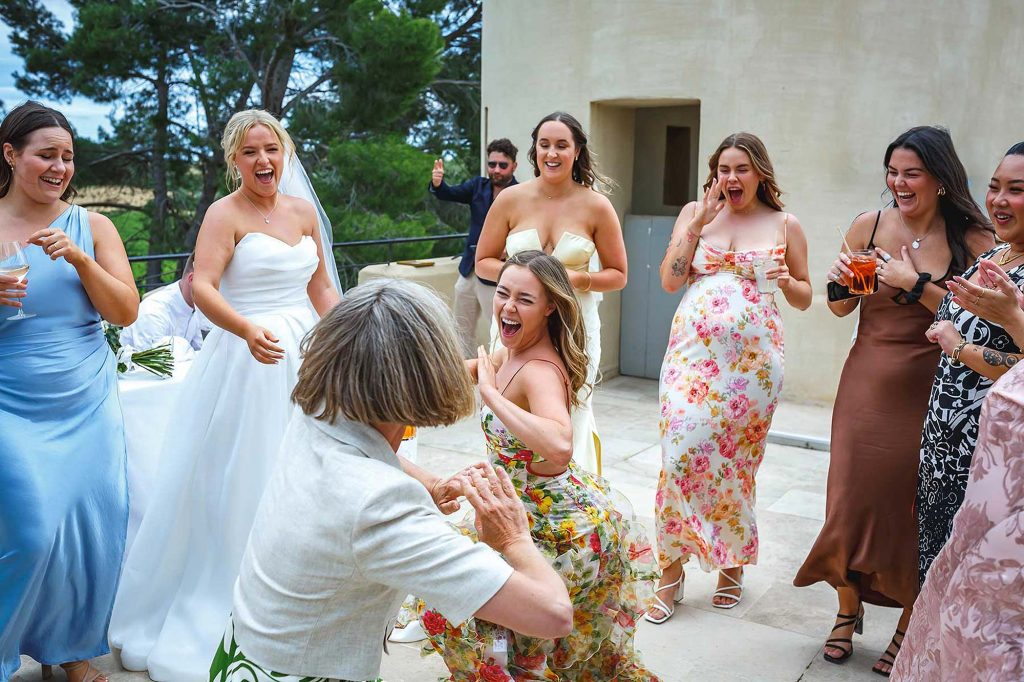 A photojournalistic wedding image of girls dancing during the day.