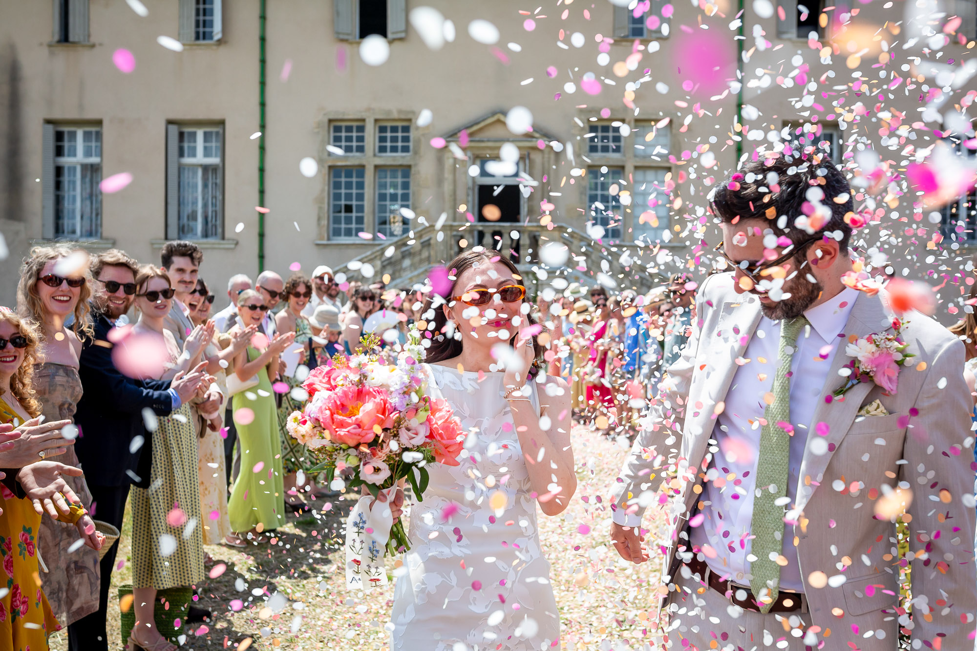 Newlyweds walking through colourful confetti after their ceremony near Pézenas