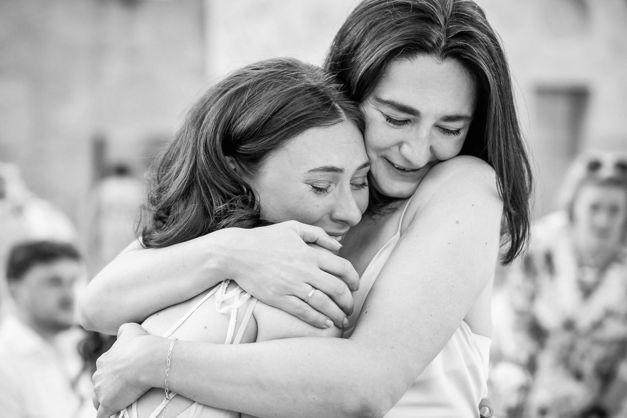 Bride embracing a close friend during a wedding reception near Pézenas