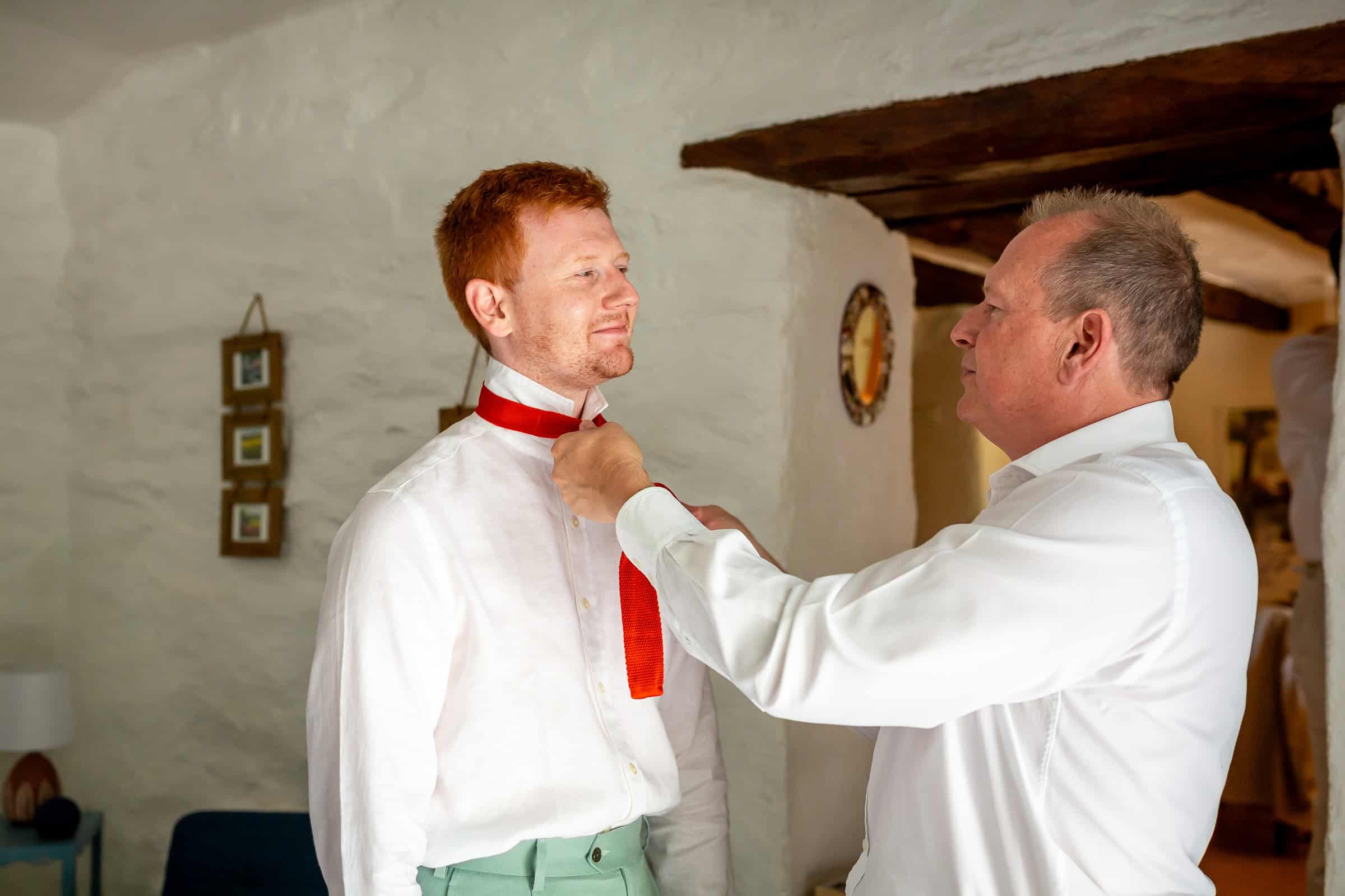 Alexander having his tie adjusted while getting ready