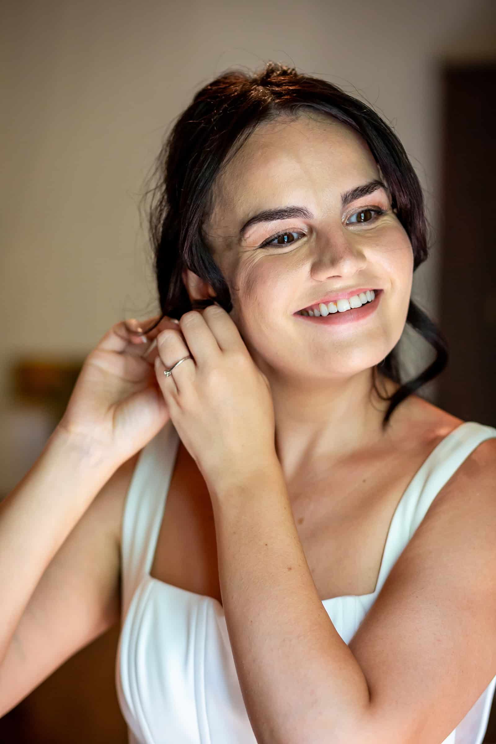 Kayley putting on an earring while getting ready