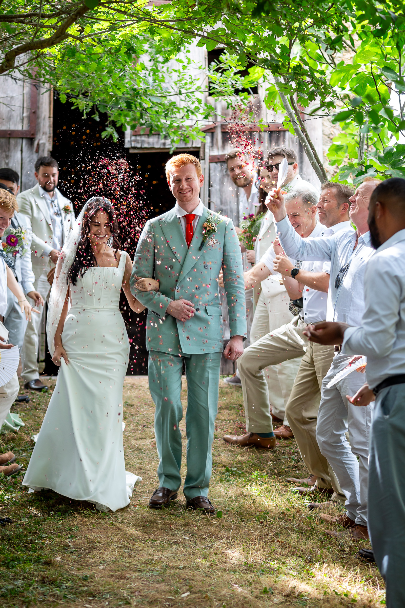 Kayley and Alexander walking through dried-flower confetti outside the barn