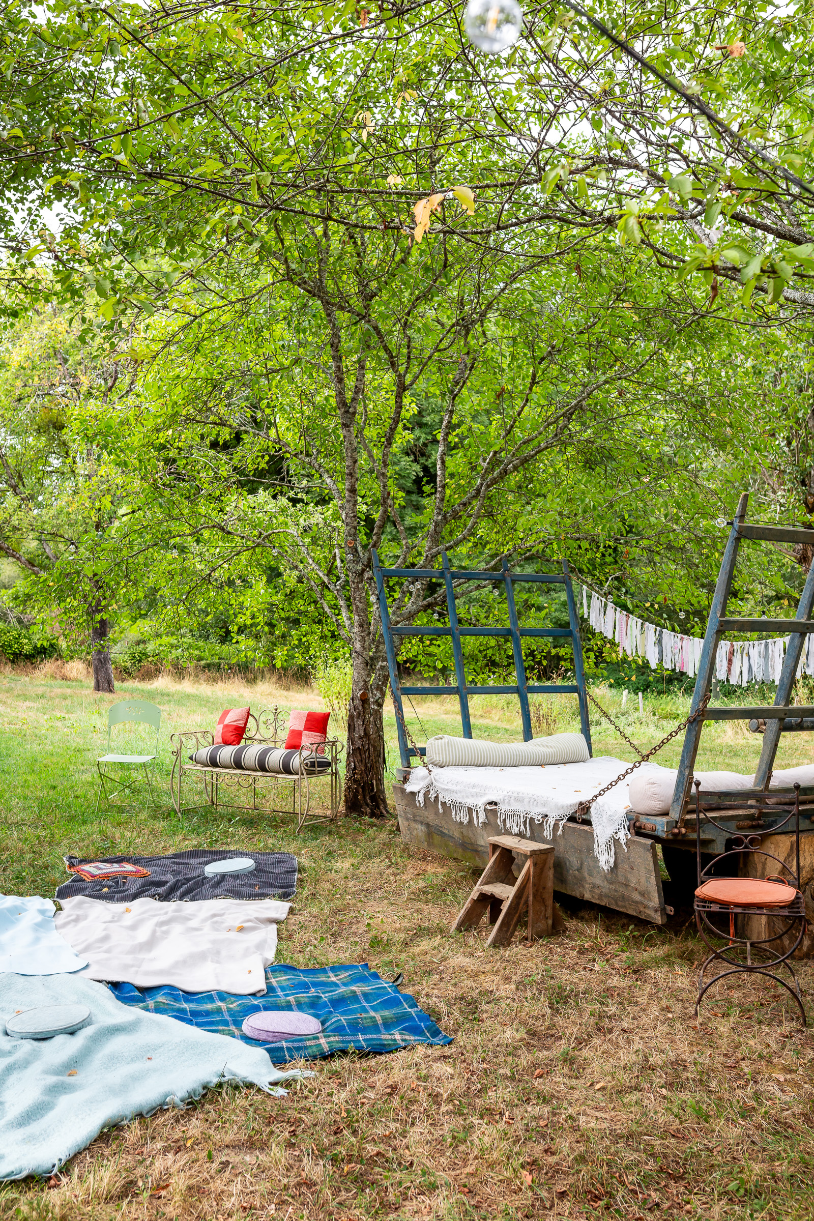 An old cart arranged with blankets and cushions for the outdoor reception