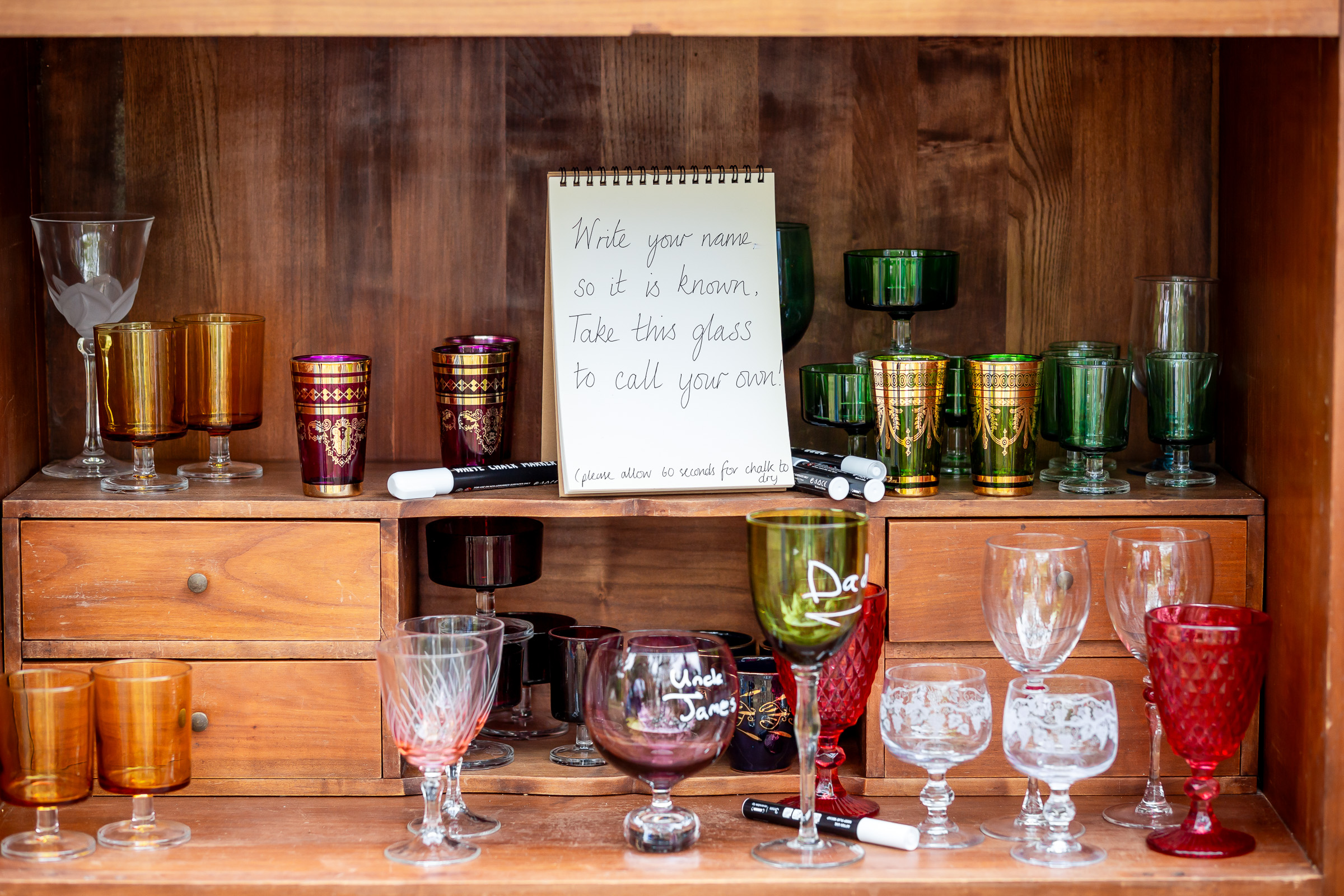 A handwritten note beside the collection of mismatched wedding glasses