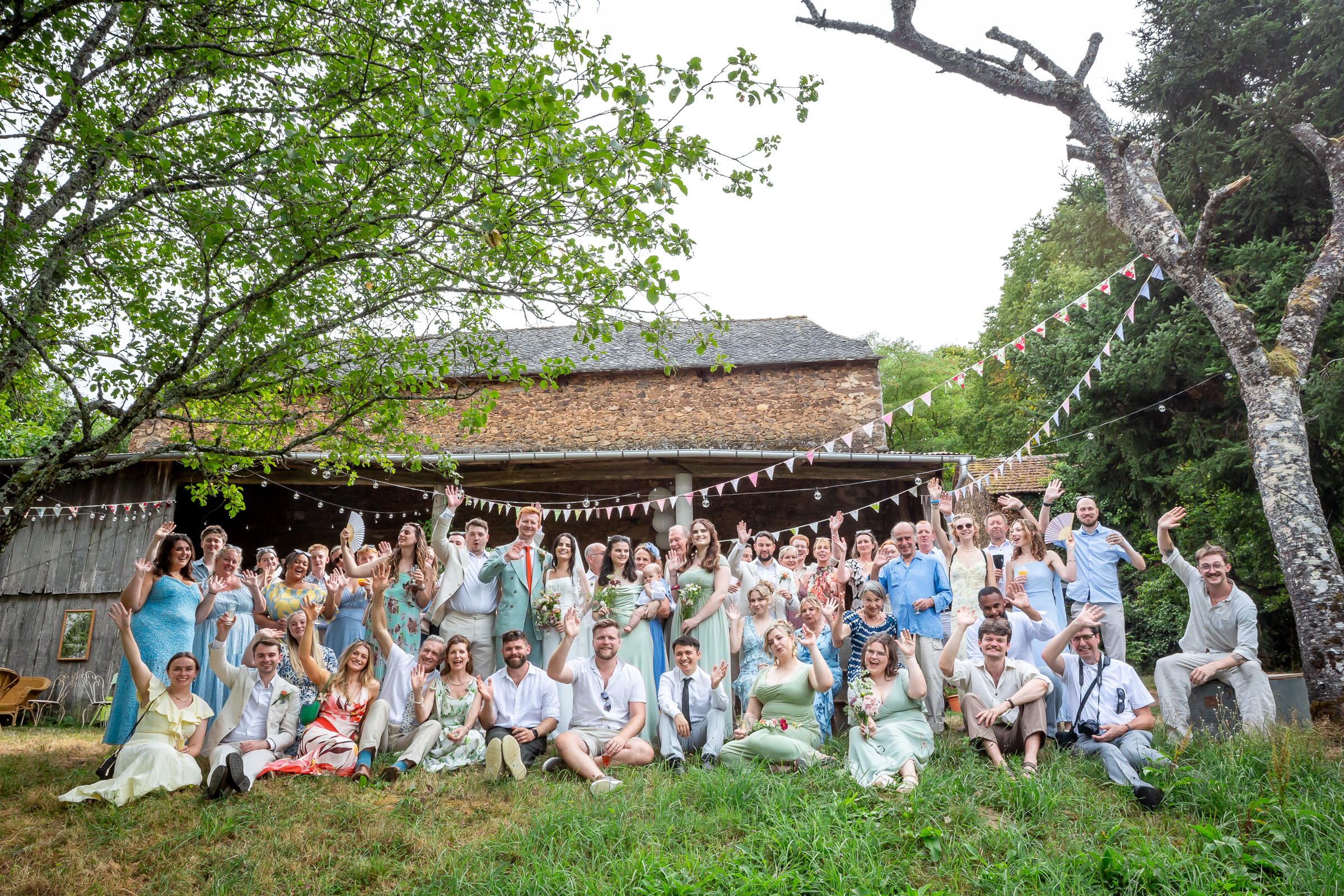 Kayley and Alexander with around 60 wedding guests outside the family barn