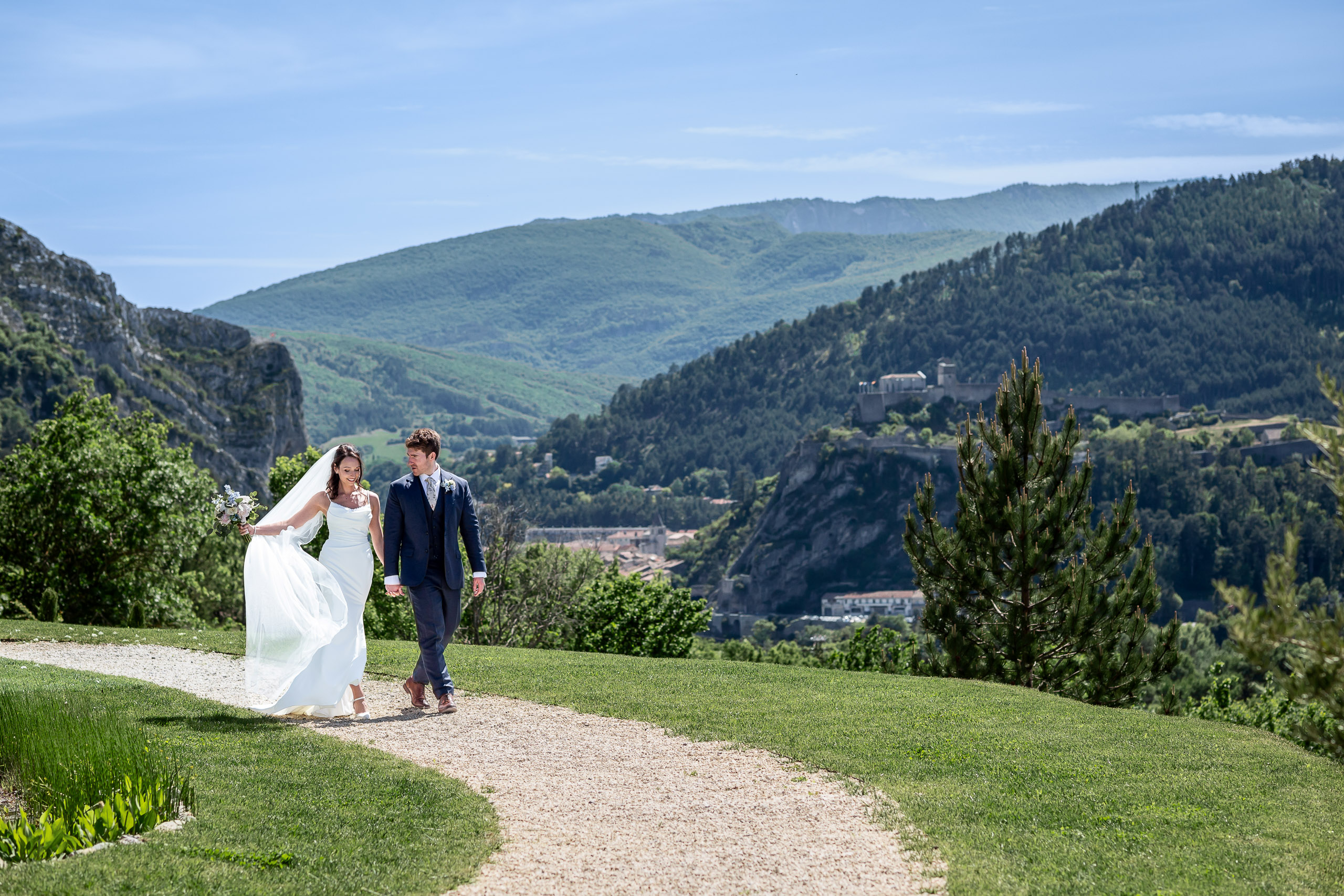 Newlyweds walking through a mountain landscape at their Provence wedding