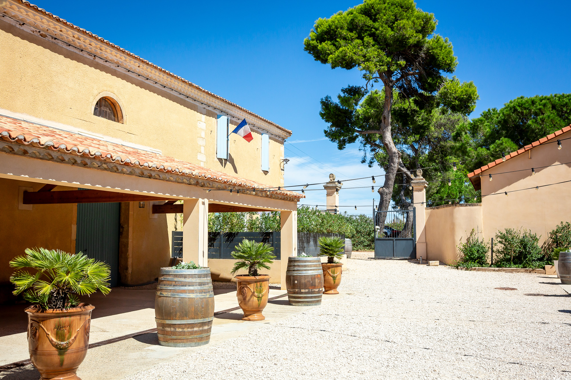 Cream-stone exterior, blue shutters and wine barrels at Château Bellefontaine