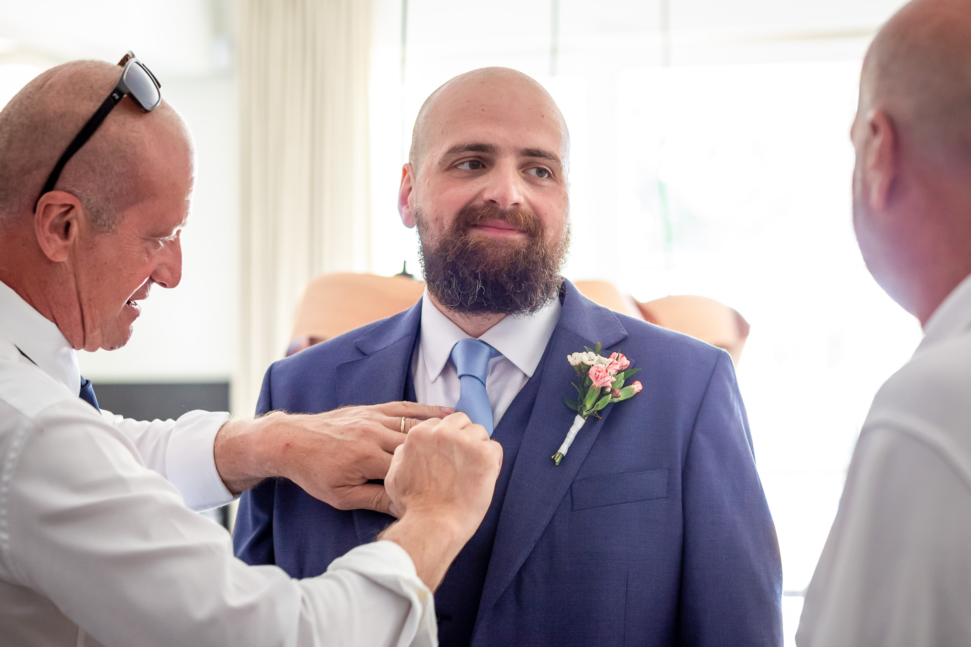 Thomas’s father fastening his buttonhole before the ceremony