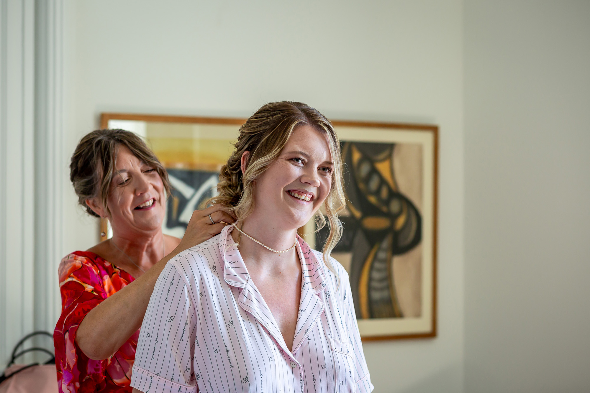 Hannah laughing as her hair is finished before the wedding
