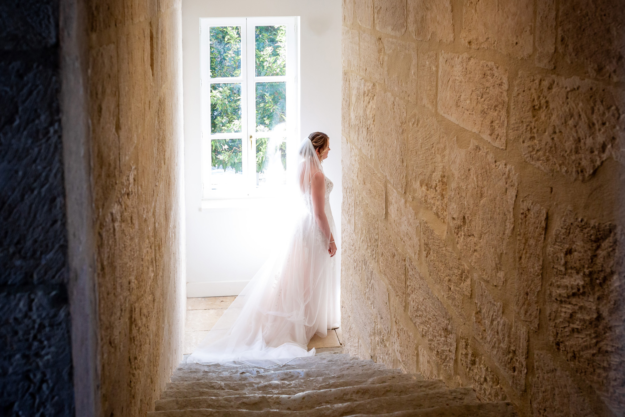Hannah walking down an old stone staircase at Château Bellefontaine