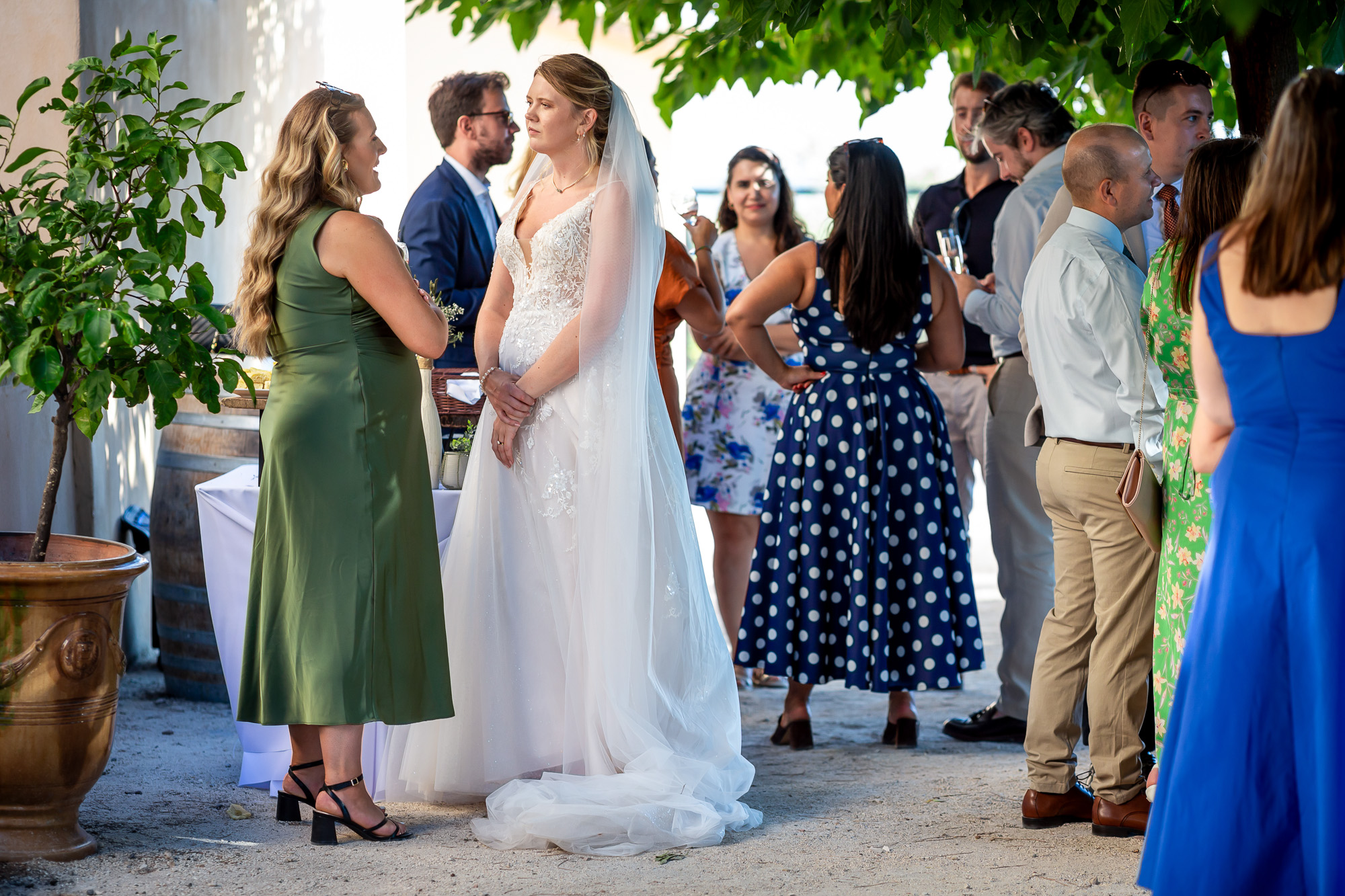 Hannah and Thomas talking with guests in a shaded exterior space at Château Bellefontaine