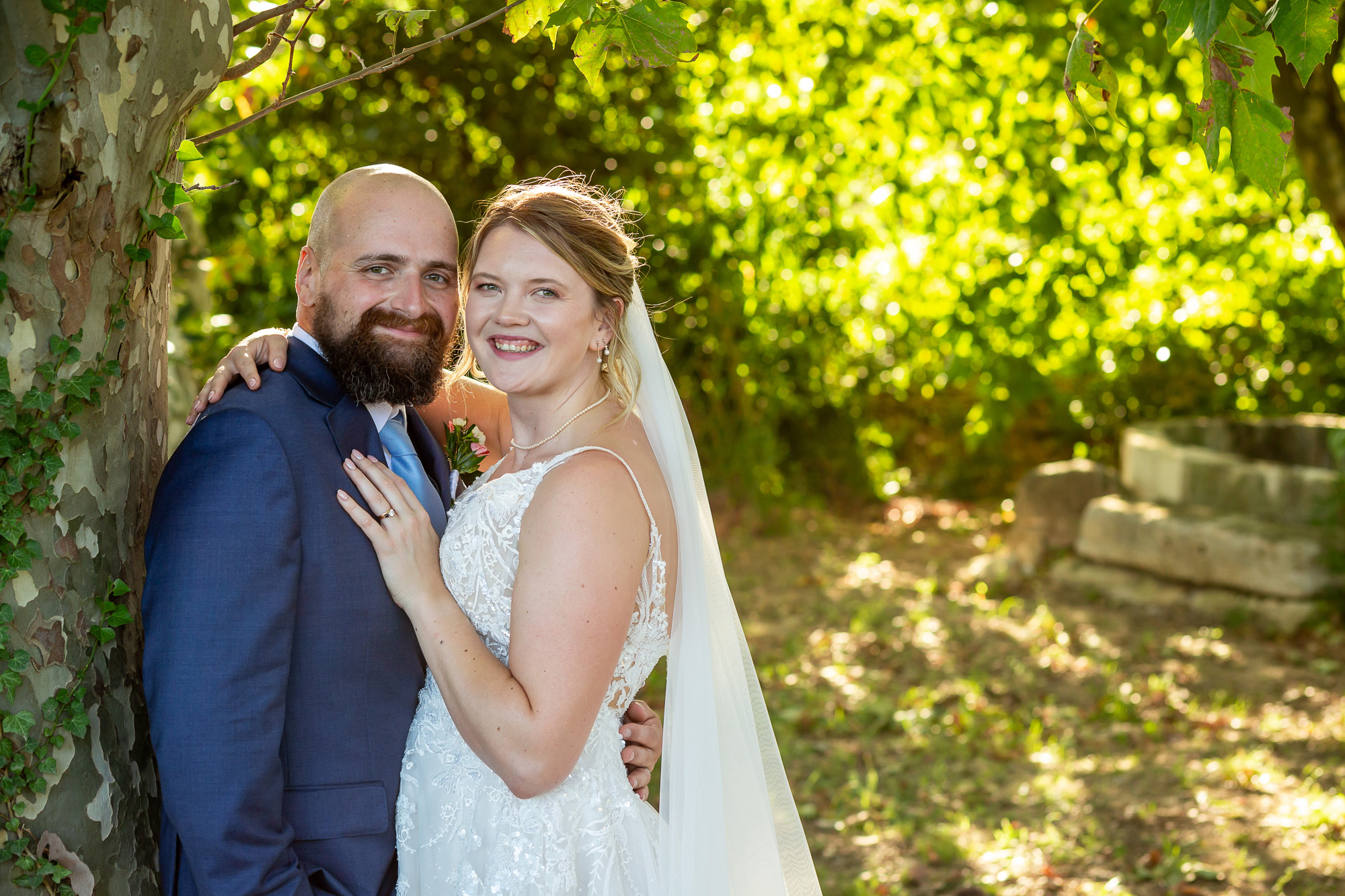 A relaxed portrait of Hannah and Thomas beneath the trees