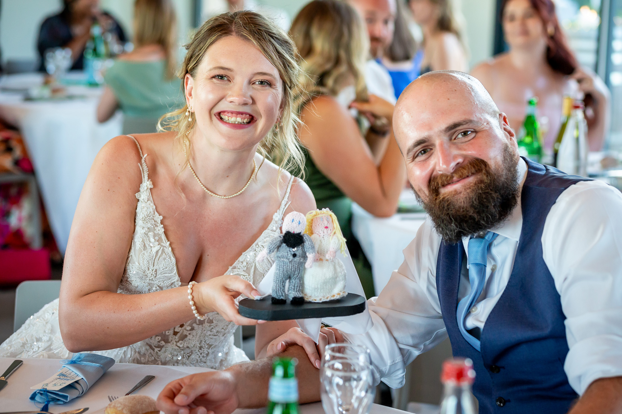 Hannah and Thomas holding their crocheted wedding dolls