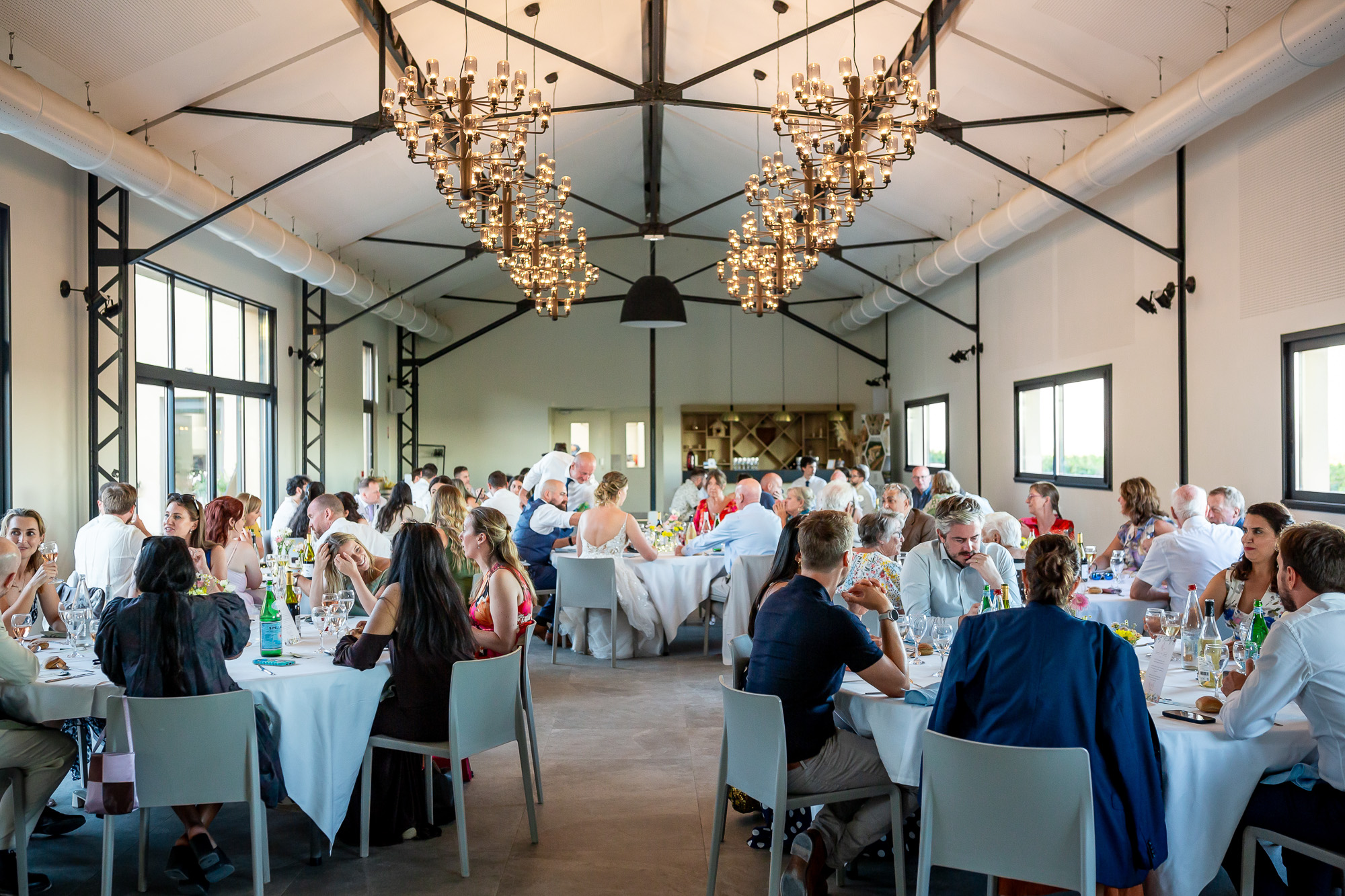 Guests seated for dinner in the bright Château Bellefontaine reception room