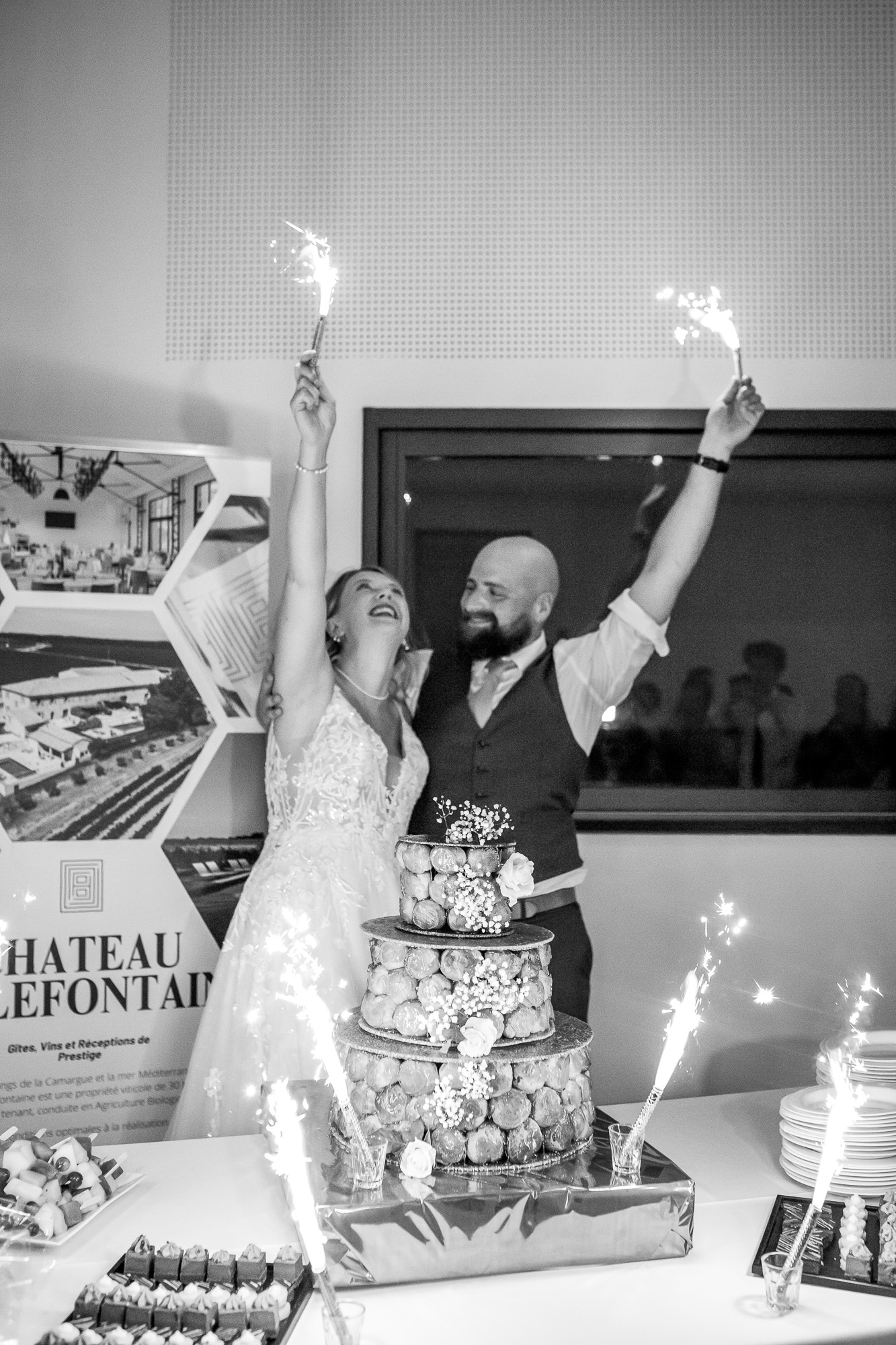 Hannah and Thomas beside their croquembouche as sparklers burn