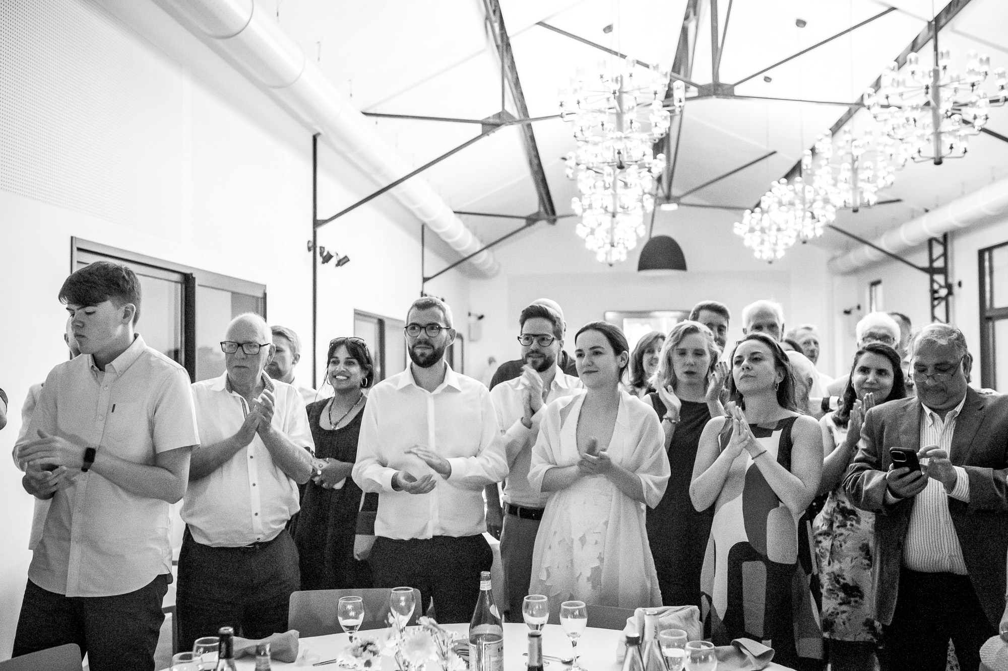 Wedding guests standing and applauding the arrival of the croquembouche