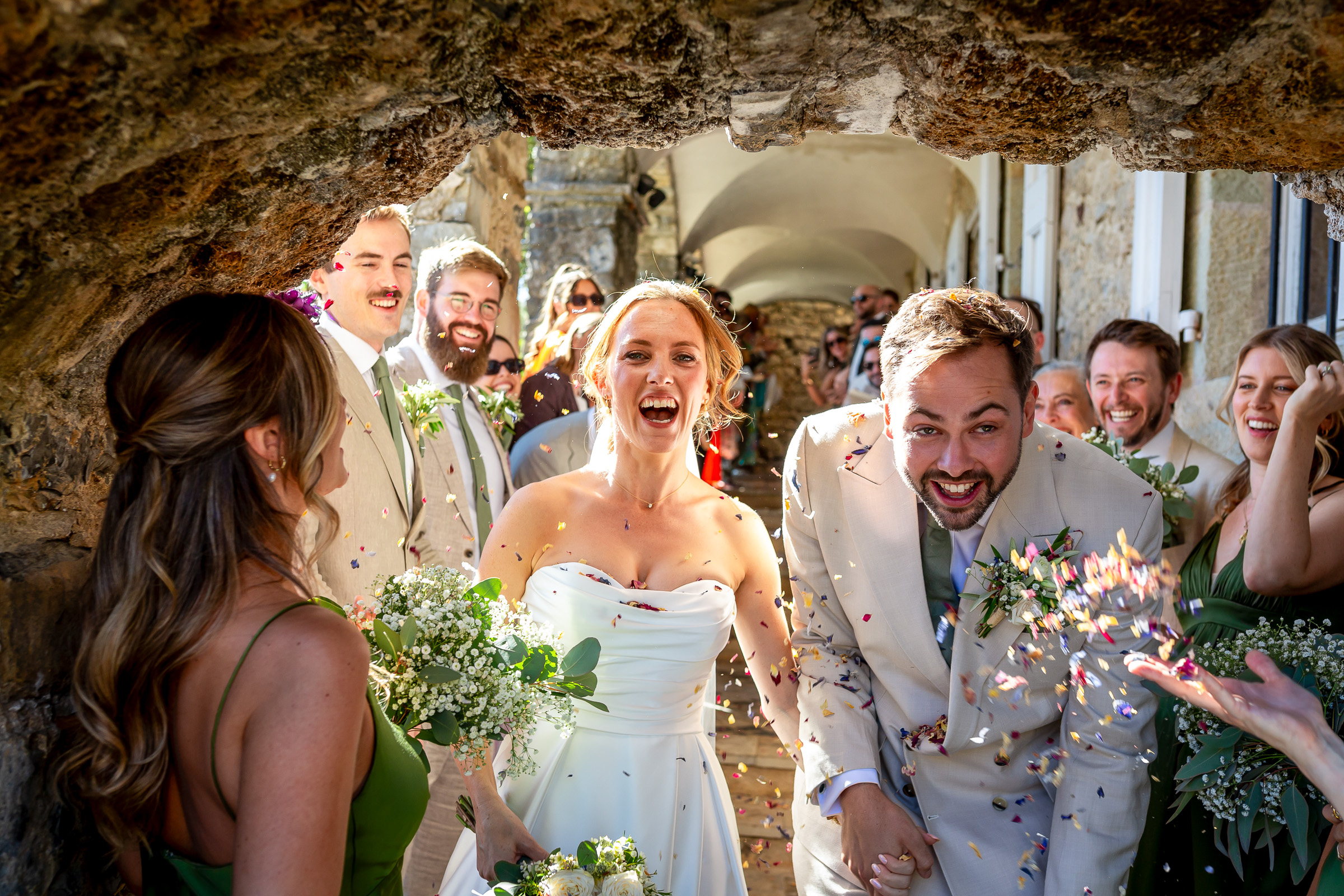 Emma and Rowan laughing beneath a shower of dried rose petals
