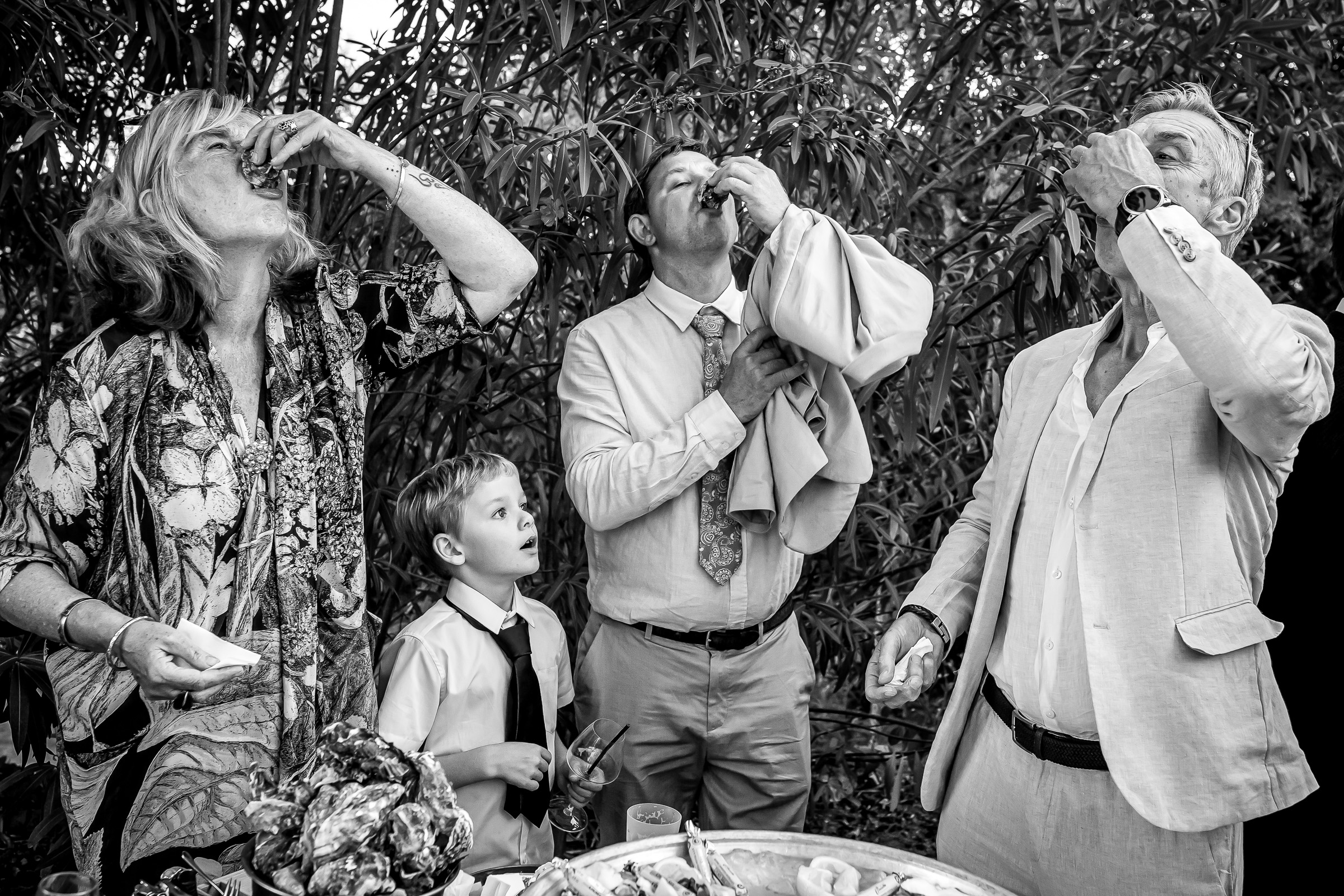 Guests eating oysters during the wedding drinks reception at Le Domaine du Rey