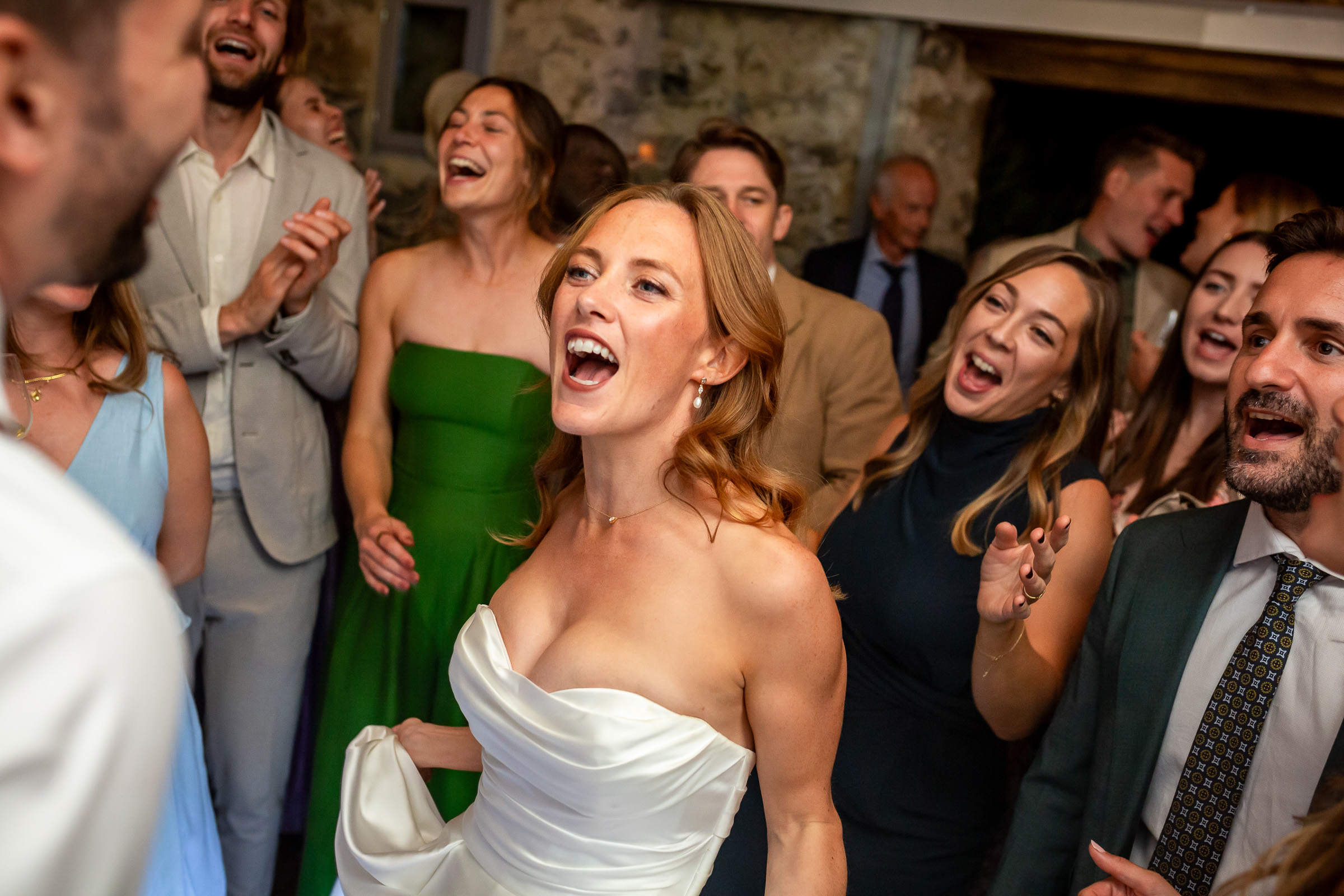 Emma laughing on the packed wedding dance floor